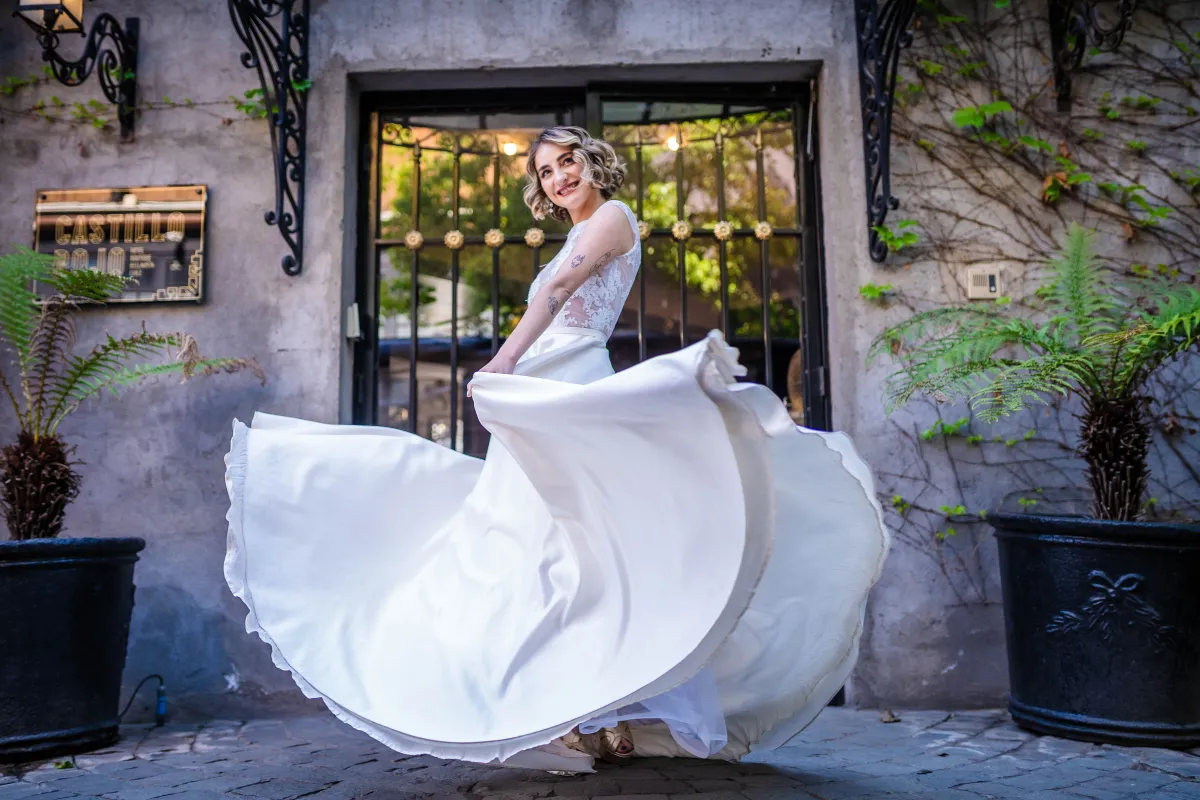 Novia girando su vestido en la entrada de piedra del castillo